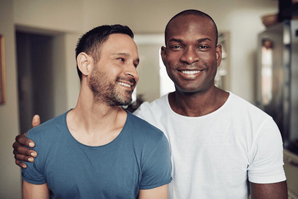 Two men smiling for a picture while standing next to each other.